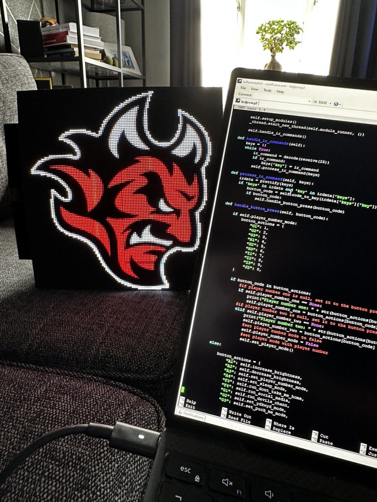 LED matrix panel alongside Python source code on a laptop